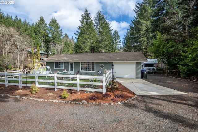 single story home with a garage, a fenced front yard, and concrete driveway