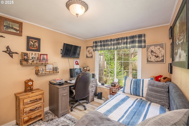 home office with light wood-style floors, baseboards, and crown molding