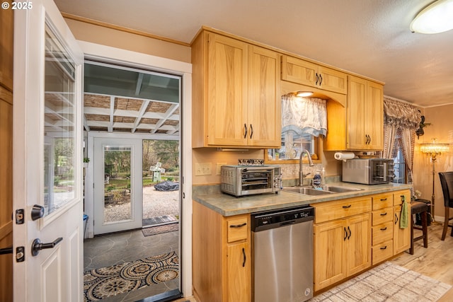 kitchen featuring dishwasher, light brown cabinetry, a sink, and a toaster