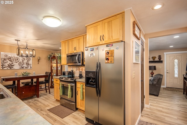 kitchen with recessed lighting, light countertops, light brown cabinetry, appliances with stainless steel finishes, and light wood-type flooring