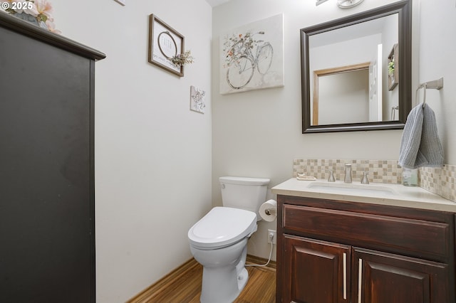 bathroom with vanity, toilet, wood-type flooring, and decorative backsplash