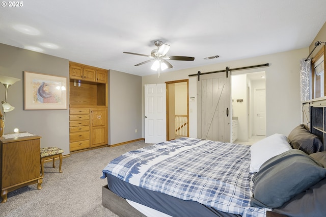 carpeted bedroom featuring a barn door and ceiling fan