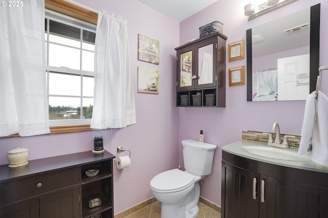 bathroom with tasteful backsplash, tile patterned floors, vanity, and toilet