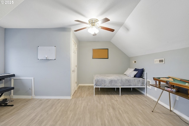 bedroom featuring vaulted ceiling, ceiling fan, light hardwood / wood-style floors, and a textured ceiling