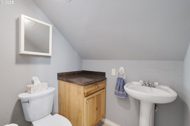 bathroom featuring vaulted ceiling, a textured ceiling, and toilet