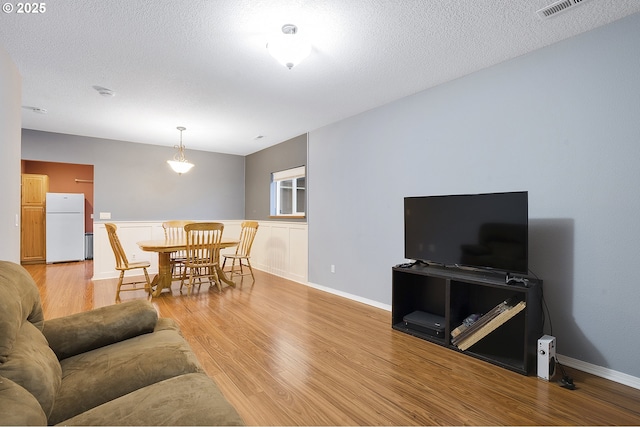 living room featuring a textured ceiling and light wood-type flooring