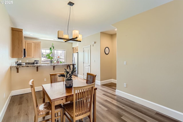 dining area featuring baseboards and light wood finished floors