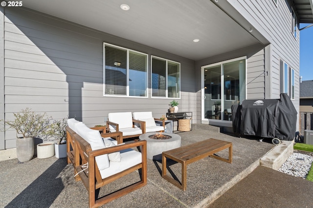 view of patio with a grill and an outdoor living space with a fire pit