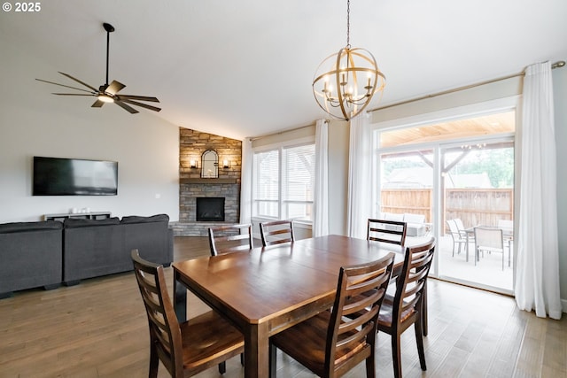 5300 Davis St SE, Turner, OR 97392 - dining space featuring light wood-type flooring, healthy amount of natural light, a stone fireplace, lofted ceiling, and a chandelier