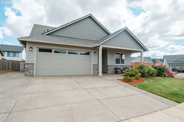 5300 Davis St SE, Turner, OR 97392 - craftsman-style house featuring stone siding, an attached garage, concrete driveway, and covered porch