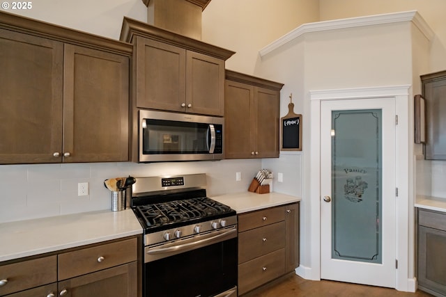 5300 Davis St SE, Turner, OR 97392 - kitchen with appliances with stainless steel finishes, backsplash, light countertops, and dark brown cabinetry