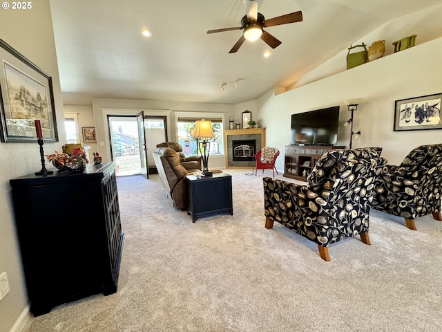 carpeted living area with a tiled fireplace, recessed lighting, lofted ceiling, and ceiling fan