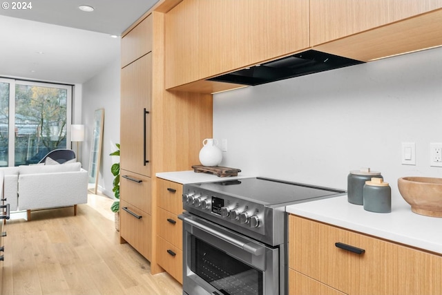 2795 NW Thurman St, Portland, OR 97210 - kitchen with stainless steel range with electric cooktop, exhaust hood, light brown cabinets, open floor plan, and light countertops