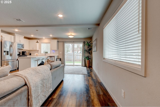 9911 SE Duke St, Portland, OR 97266 - living area featuring baseboards, a textured ceiling, visible vents, and dark wood-type flooring