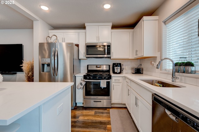9911 SE Duke St, Portland, OR 97266 - kitchen featuring white cabinetry, tasteful backsplash, appliances with stainless steel finishes, and a sink
