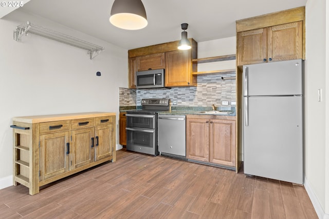 kitchen with backsplash, wood-type flooring, stainless steel appliances, and sink