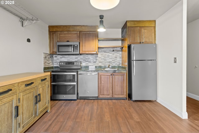 kitchen featuring appliances with stainless steel finishes, dark hardwood / wood-style floors, sink, and decorative backsplash