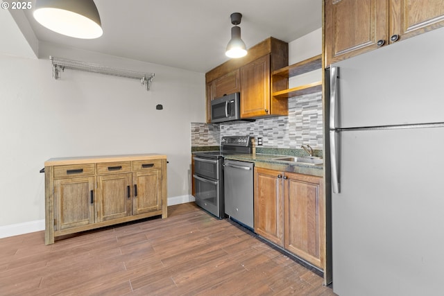 kitchen featuring sink, backsplash, stainless steel appliances, and hardwood / wood-style flooring