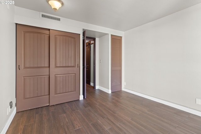 unfurnished bedroom featuring dark hardwood / wood-style floors