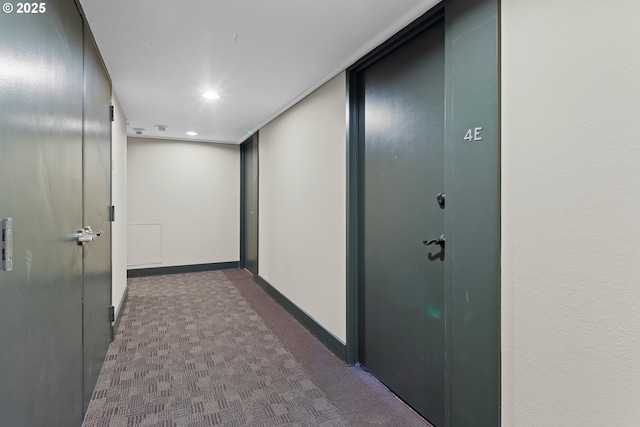 hall with dark colored carpet