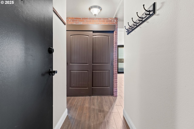 corridor with hardwood / wood-style flooring