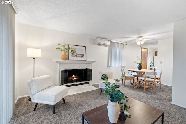 carpeted living room featuring ceiling fan, a fireplace, a textured ceiling, and a wall mounted air conditioner