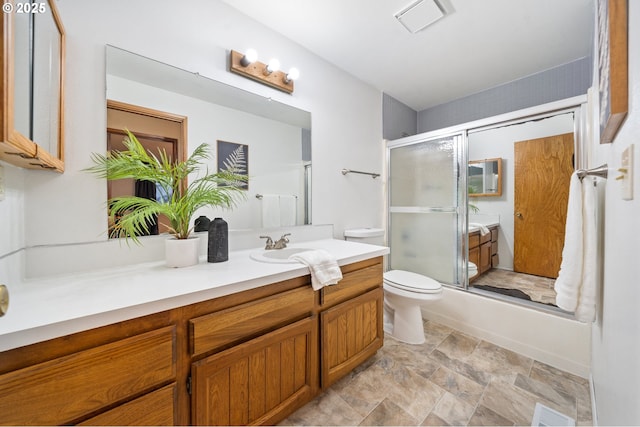 full bath featuring shower / bath combination with glass door, visible vents, toilet, stone finish flooring, and vanity