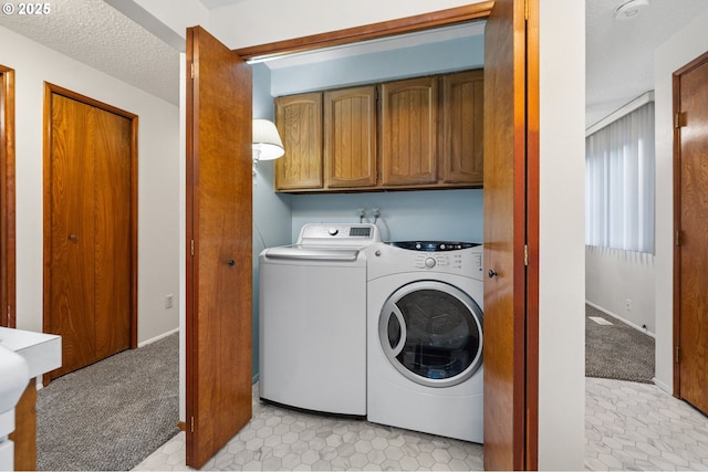 clothes washing area featuring light carpet, cabinet space, separate washer and dryer, and a textured ceiling