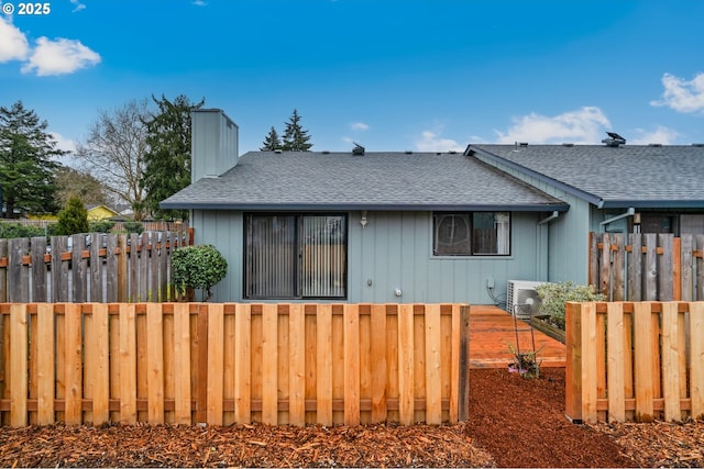 view of front of home featuring a shingled roof, fence private yard, and a chimney