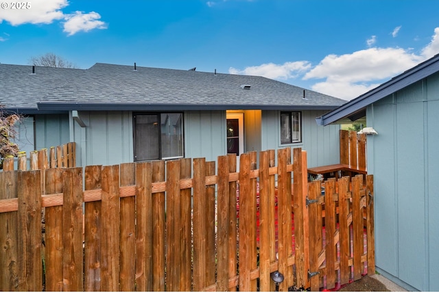 view of front of house with roof with shingles and fence