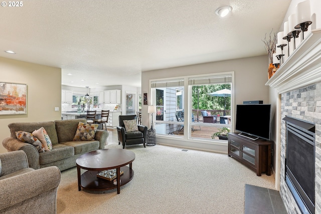 living room featuring carpet flooring, recessed lighting, a textured ceiling, and a fireplace with flush hearth