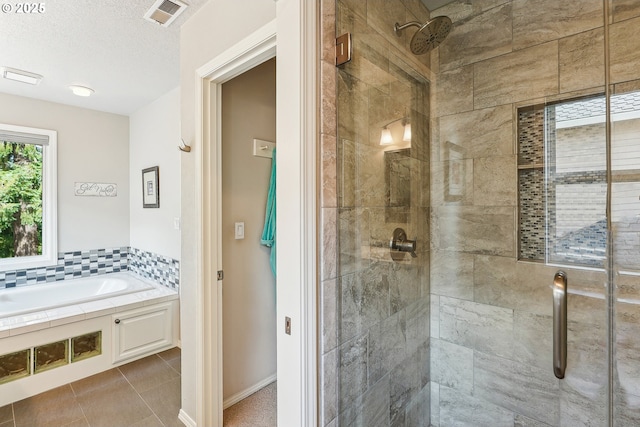 bathroom with tile patterned floors, a shower stall, a bath, and visible vents