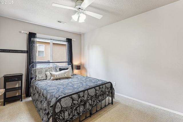 carpeted bedroom featuring baseboards, ceiling fan, a textured ceiling, and visible vents