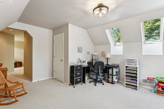 office space with baseboards, carpet, lofted ceiling with skylight, and visible vents
