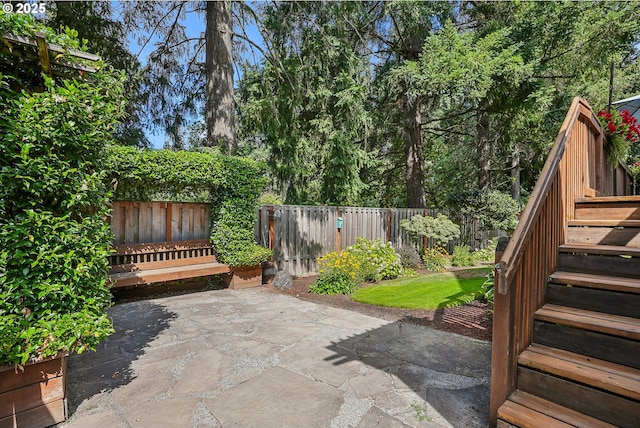 view of patio with stairs and a fenced backyard