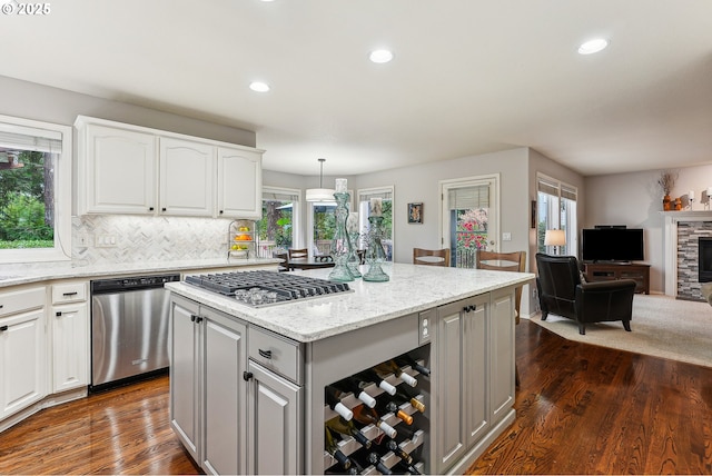 kitchen featuring dark wood-style floors, a center island, gray cabinets, white cabinetry, and stainless steel appliances