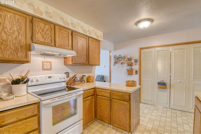 1318 SW 39th Ave, Pendleton, OR 97801 - kitchen with white electric range, under cabinet range hood, a peninsula, light countertops, and a textured ceiling