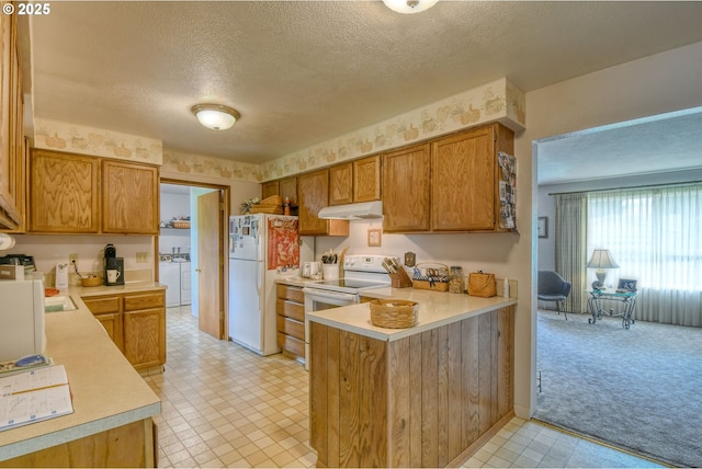 1318 SW 39th Ave, Pendleton, OR 97801 - kitchen with separate washer and dryer, white appliances, light countertops, a peninsula, and a textured ceiling