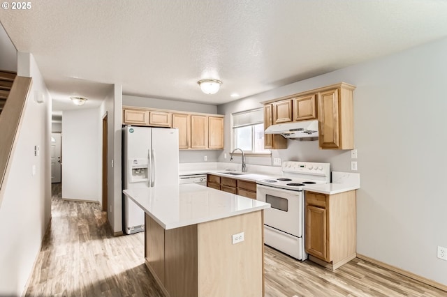 1165 SE 85th Ave, Portland, OR 97216 - kitchen featuring white appliances, under cabinet range hood, light brown cabinets, light wood finished floors, and a textured ceiling
