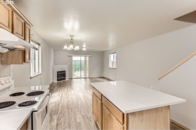 1165 SE 85th Ave, Portland, OR 97216 - kitchen featuring white electric range, a chandelier, a center island, light wood-style flooring, and open floor plan
