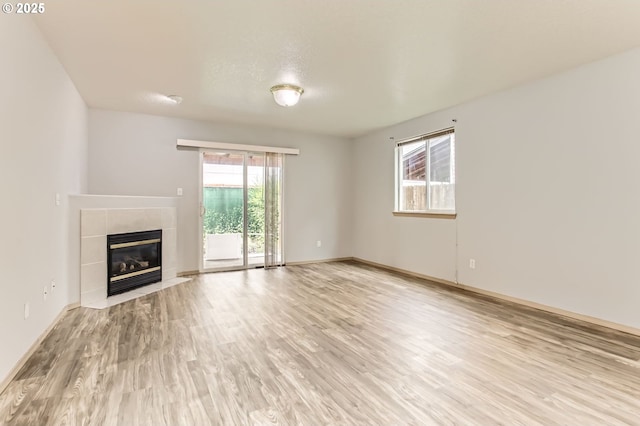 1165 SE 85th Ave, Portland, OR 97216 - unfurnished living room with light wood-style flooring and a fireplace