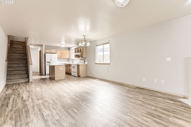 1165 SE 85th Ave, Portland, OR 97216 - unfurnished living room featuring a chandelier, light wood-style flooring, and stairs