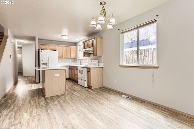 1165 SE 85th Ave, Portland, OR 97216 - kitchen with white appliances, under cabinet range hood, light countertops, a chandelier, and light wood-style flooring