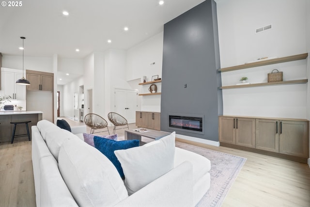 5404 NE 111th St, Vancouver, WA 98686 - living room with light wood finished floors, a glass covered fireplace, a towering ceiling, and recessed lighting