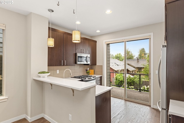 5026 SE Mill St, Portland, OR 97215 - kitchen featuring appliances with stainless steel finishes, light wood-style flooring, plenty of natural light, and recessed lighting