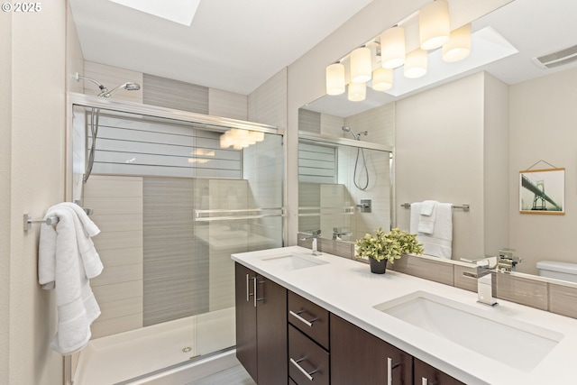 5026 SE Mill St, Portland, OR 97215 - bathroom with double vanity, a shower stall, and toilet