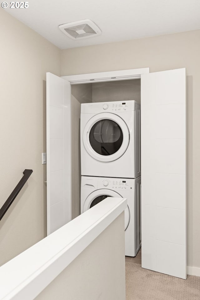 5026 SE Mill St, Portland, OR 97215 - washroom with stacked washing machine and dryer and light colored carpet