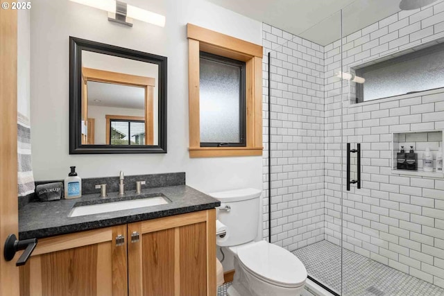 full bathroom featuring a shower stall, vanity, and toilet