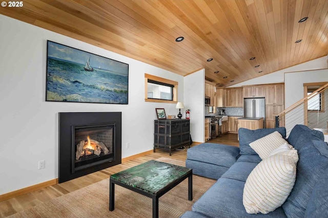 living area featuring vaulted ceiling, wooden ceiling, baseboards, a fireplace with flush hearth, and light wood-style floors