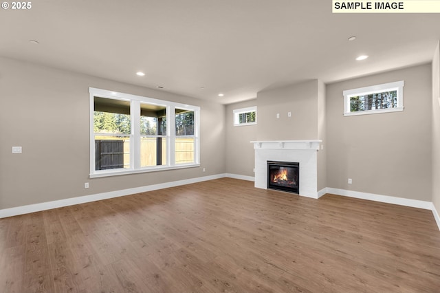 17301 SW Atfalati Ln Unit 38, Sherwood, OR 97140 - unfurnished living room with recessed lighting, wood finished floors, and a glass covered fireplace